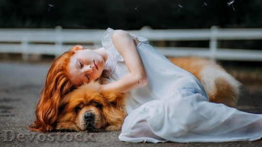 Devostock Red hair little girl laying over dog 