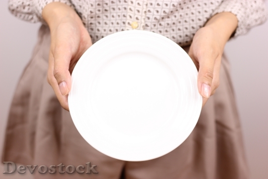 Devostock Girl Holds Dish