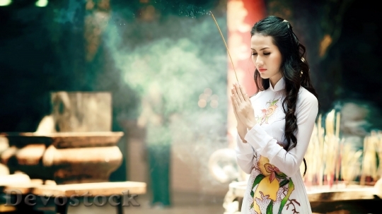 Devostock A beautiful Asian girl praying