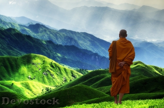Devostock A monk standing on green mountain during daytime