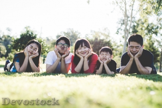 Devostock Asian family with close eyes lying on the meadow