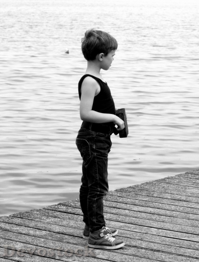 Devostock Black and white photo of a Boy looking at the sea