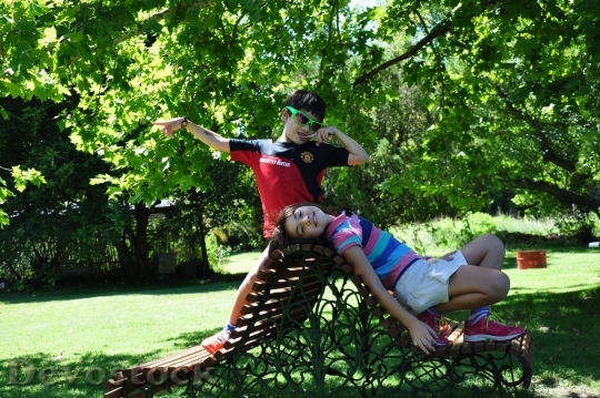 Devostock Boy and girl in the park setting on the bench