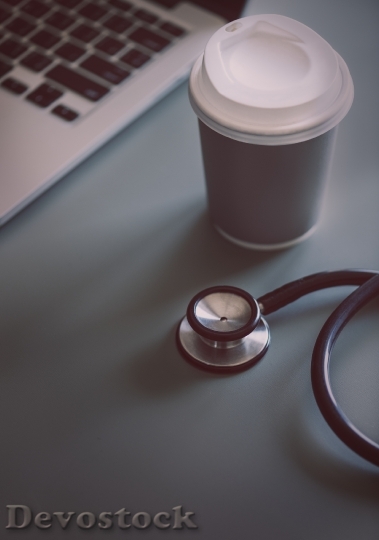 Devostock Closeup of doctor stethoscope with coffee paper cup