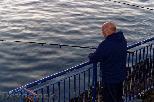 Devostock Man Fishing Harbor Sunset
