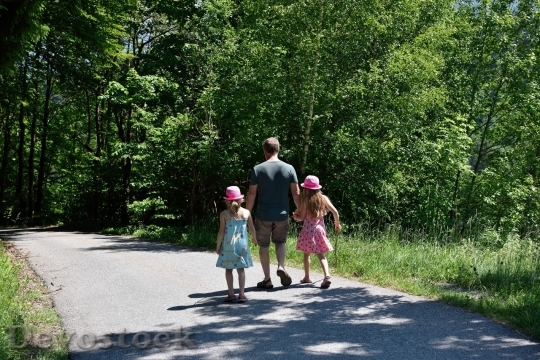 Devostock Father with girls walking in the woods