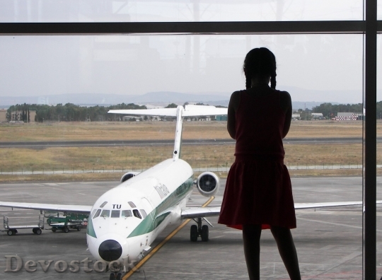 Devostock Girl looking at aeroplane