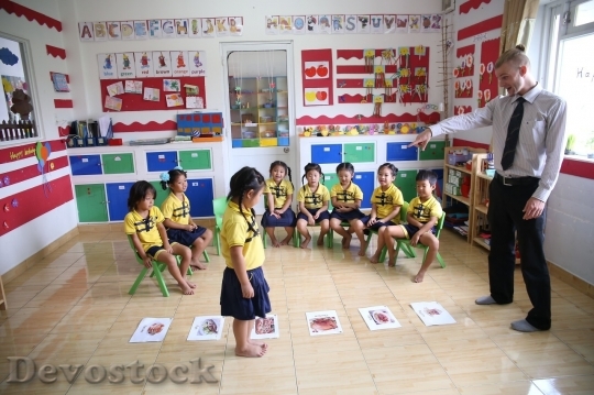 Devostock White teacher playing with Asian students