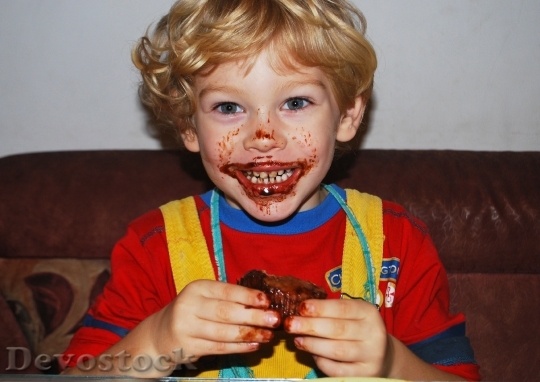 Devostock Boy Eating Chocolate Muffin