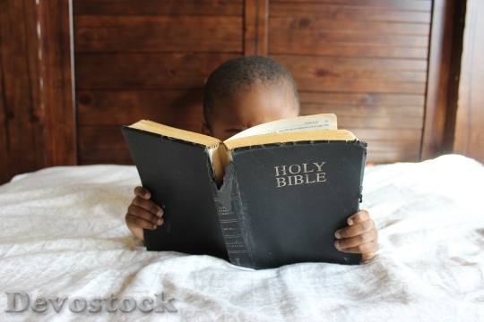 Devostock Child Reading Bible Bed